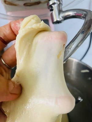 生地をスピード2で3分間こね、材料をなじませます。その後、スピード5～6でさらに6分間こね、生地が少しギザギザの膜状になるまでこねます（完璧を目指さないでください。これはまだ半完成の膜です）。バターと塩を加え、スピード2で3分間こねてバターを吸収させます。その後、スピード5～6でさらに8～10分間こね、「グローブフィルム」（破ったときに滑らかな縁を持つ薄く半透明の膜。柔らかいパンを作る秘訣です！）になるまでこねます。