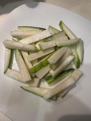 ปอกเปลือกบวบแล้วหั่นเป็นชิ้นยาวๆ