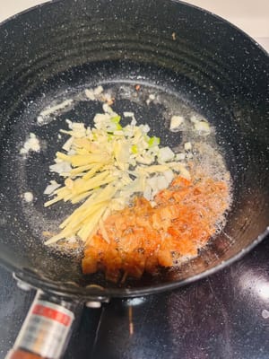 ใส่ขิง กระเทียม และต้นหอมลงไป ผัดต่อไปเรื่อยๆ