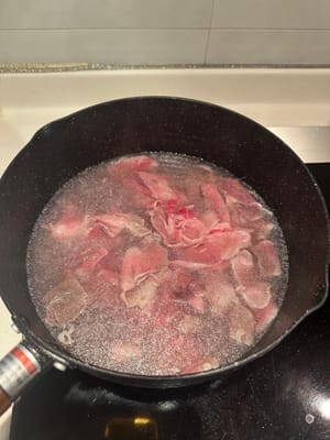 ลวกเนื้อวัวในน้ำเดือดสักครู่จนเปลี่ยนเป็นสีน้ำตาล นำออกจากหม้อเมื่อสุกแล้ว