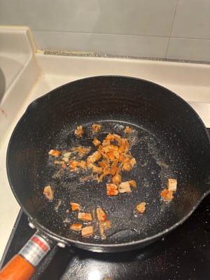 นำกุ้งแห้งและหอยเชลล์ไปผัดในกระทะที่ร้อนใส่น้ำมัน