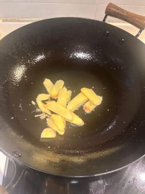 ในกระทะอีกใบ ให้ผัดขิงหั่นบางๆ จนเหลืองเล็กน้อย