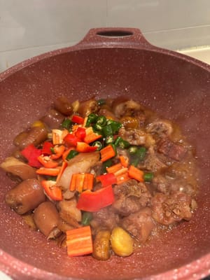 ใส่พริกแดงและพริกเขียวสับลงไป ผัดให้เข้ากันจนซอสข้นขึ้น