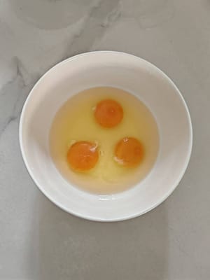 Pecahkan tiga butir telur ke dalam mangkuk.