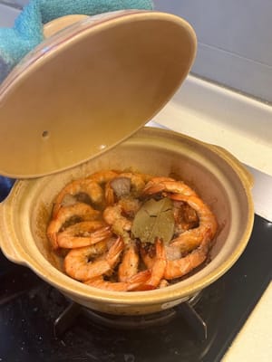 Nach dem Garen die Gewürze entfernen und mit Frühlingszwiebeln garnieren.