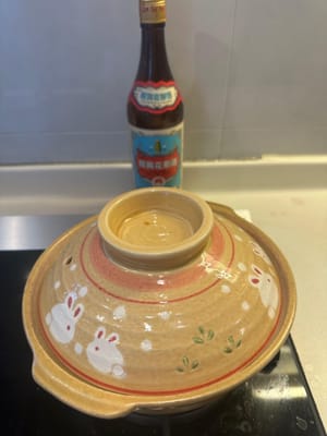 Mit einem Deckel abdecken und Hua Tiao-Wein über den Deckel gießen. 8 Minuten bei schwacher Hitze backen lassen.