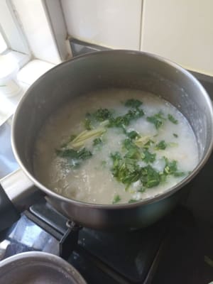 Añade la carne de pescado a la papilla, cocina durante unos 5 minutos y agrega jengibre en rodajas, cebolletas y hojas de cilantro.