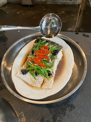 在鱼上加入3汤匙酱油。然后将3汤匙热花生油淋在鱼上。