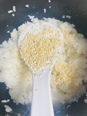 拌制米饭:米饭煮熟后稍冷却,倒入寿司醋搅拌均匀,有熟芝麻的话撒点进去,香气更足。