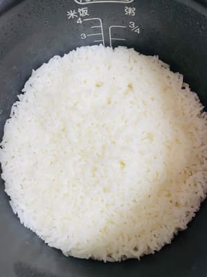 煮米饭:
将米淘洗干净,按个人食量放入电饭煲煮熟。参考用量:150克(1杯)米可煮2碗饭,本次用1.5杯米。