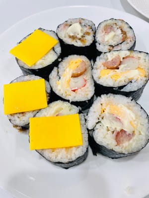 切分与装饰:
用锋利的刀将寿司卷切成小段,表面可再抹少许沙拉酱,方便粘合芝士片,再摆上甜虾。若有吞拿鱼、海草、鱼子等食材,也可随心添加。