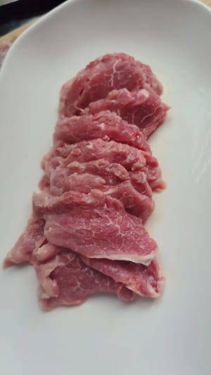 Tagliare la carne a fette dello spessore di due monete, aggiungere un po' di sale e pepe, mescolare bene e lasciare marinare per qualche minuto per farle assorbire un po' di sapore.