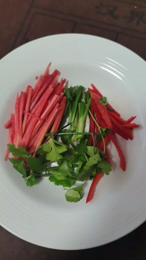 tritare alcuni cipollotti, coriandolo e carote per aggiungere colore.