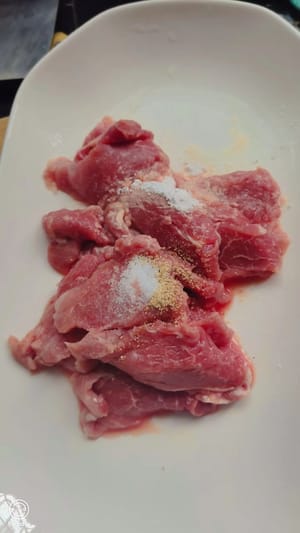 Tagliare la carne a fette dello spessore di due monete, aggiungere un po' di sale e pepe, mescolare bene e lasciare marinare per qualche minuto per farle assorbire un po' di sapore.