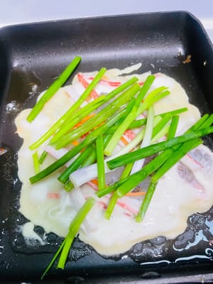 Goreng adonan dasar pancake hingga berwarna cokelat keemasan dan matang. Pertama, letakkan makanan laut dan potongan daun bawang secukupnya di atasnya, lalu tambahkan irisan cabai (saya menggantinya dengan irisan wortel). Selanjutnya, tuang 1/4 adonan.