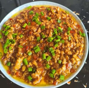 這時把炒好的肉末輕輕鋪在豆腐上面，撒上蔥花點綴完成。