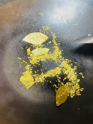 Successivamente, usa il calore residuo nella padella per soffriggere i semi di finocchio e le foglie di alloro fino a quando non saranno fragranti, quindi mettili da parte. Se usi semi di sesamo bianco crudi, soffriggili a fuoco basso fino a quando non saranno leggermente gialli e profumati; se usi semi di sesamo cotti, usali direttamente.