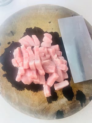 Preparazione del filetto di maiale: per rendere il maiale più saporito, ho tagliato la carne in piccoli pezzi e l'ho frullata nel frullatore per un uso successivo. Se non avete un frullatore, potete tagliarlo in granuli e metterlo in acqua fredda. Aggiungere il vino da cucina e le fette di zenzero e mettere da parte.