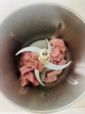 Preparazione del filetto di maiale: per rendere il maiale più saporito, ho tagliato la carne in piccoli pezzi e l'ho frullata nel frullatore per un uso successivo. Se non avete un frullatore, potete tagliarlo in granuli e metterlo in acqua fredda. Aggiungere il vino da cucina e le fette di zenzero e mettere da parte.