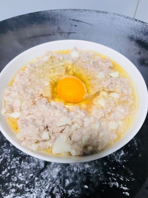 將拌好的肉末平鋪在盤子裡，中間用湯匙壓出一個小窩。水開蒸5分鐘定型，再打入一顆雞蛋。