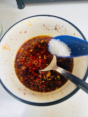 準備料汁：取乾淨碗，放 2 - 3 匙乾辣椒麵（或辣椒碎，依吃辣程度調整）、3 - 5 瓣蒜末。燒 180 - 200℃植物油，潑入碗中激香。接著加 3 匙生抽、3 匙陳醋、1 小匙白糖、1 小匙鹽、1 小匙香油，攪拌均勻成料汁 。