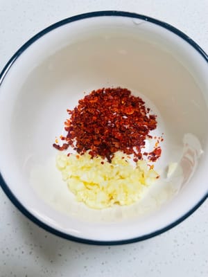 準備料汁：取乾淨碗，放 2 - 3 匙乾辣椒麵（或辣椒碎，依吃辣程度調整）、3 - 5 瓣蒜末。燒 180 - 200℃植物油，潑入碗中激香。接著加 3 匙生抽、3 匙陳醋、1 小匙白糖、1 小匙鹽、1 小匙香油，攪拌均勻成料汁 。