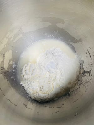 Pesare 250 g di farina 00 (o farina forte, regolare in base alla consistenza desiderata), 125-130 g di acqua potabile a temperatura ambiente e 2 g di sale. Il sale rafforza il glutine e migliora la consistenza dei noodles.
La quantità di acqua dovrebbe essere circa la metà della farina, ma questo dovrebbe anche dipendere dalla capacità di assorbimento dell'acqua della farina. Si può iniziare con 120 g di acqua e aggiungerne gradualmente altra fino a ottenere un impasto morbido.