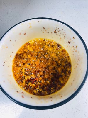 準備料汁：取乾淨碗，放 2 - 3 匙乾辣椒麵（或辣椒碎，依吃辣程度調整）、3 - 5 瓣蒜末。燒 180 - 200℃植物油，潑入碗中激香。接著加 3 匙生抽、3 匙陳醋、1 小匙白糖、1 小匙鹽、1 小匙香油，攪拌均勻成料汁 。