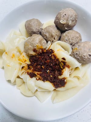 Versare immediatamente la salsa preparata in precedenza sui noodles e mescolare rapidamente con le bacchette per ricoprire uniformemente ogni noodle. Aggiungere guarnizioni (come un uovo fritto, verdure tritate o germogli di soia, che devono essere sbollentati o cotti in anticipo) per esaltare l'aspetto e la ricchezza nutrizionale dei vostri deliziosi noodles tirati a mano.