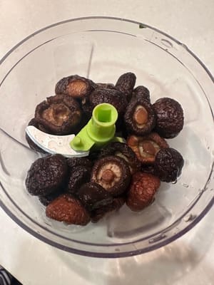 將蘑菇放入研磨機中研磨成泥，然後加入豬肉末中。