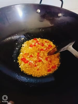 Scaldare l'olio in un'altra padella e aggiungere zenzero, aglio, peperoncino e peperoncino sottaceto. Rosolare fino a quando non saranno amari.