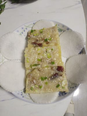 Mettere piccoli pezzetti di torta di ravanello nel piatto preparato con i fiori di ravanello.
