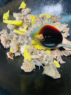 依序加入料酒、生抽、老抽、鹽、白糖，翻炒均勻，讓鴨肉均勻上色。