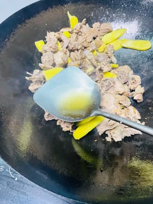 依序加入料酒、生抽、老抽、鹽、白糖，翻炒均勻，讓鴨肉均勻上色。