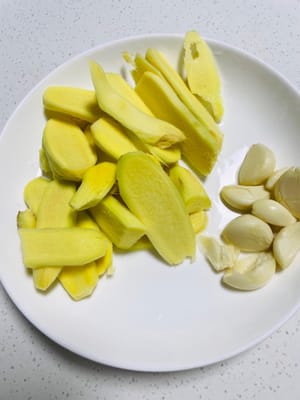 Tagliare lo zenzero a fettine e tritare l'aglio.