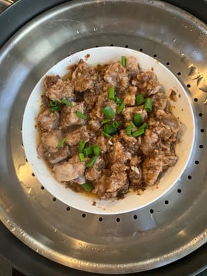 将葱花撒在蒸好的排骨上。