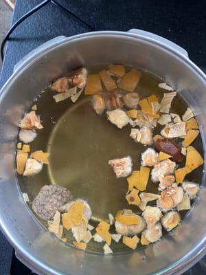 Tambahkan buah biksu, kulit jeruk mandarin dan air rendaman ke dalam panci berisi 4 liter air dingin.