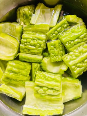 Wash the bitter melon and soak it in clean water for 20 minutes. Cut the bitter melon lengthwise, use a small spoon to scoop out the white pulp and seeds inside, cut it into appropriate pieces and soak it for another 20 minutes.