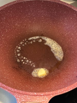 ในกระทะเดียวกัน ลดไฟลงและใส่เนยลงไป