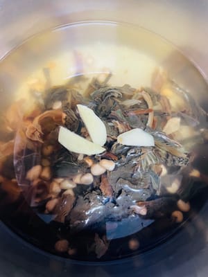 加入泡好的花生、菜乾,清洗好的豬骨以及3片薑,大火煮開後,轉小火或中小火煮1小時;若用高壓鍋,上汽後計時15-20分鐘,之後自然降溫排氣即可開蓋。
