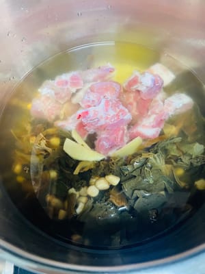 加入泡好的花生、菜乾,清洗好的豬骨以及3片薑,大火煮開後,轉小火或中小火煮1小時;若用高壓鍋,上汽後計時15-20分鐘,之後自然降溫排氣即可開蓋。