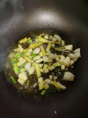 웍에 기름을 두르고 달군 후, 다진 파와 마늘을 넣고 향이 날 때까지 볶습니다.