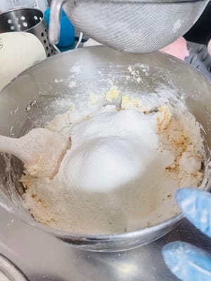 Ayak tepung kue ke dalam mentega kocok dan aduk dengan spatula hingga tidak ada gumpalan. Jangan menguleni terlalu keras, karena akan menyebabkan tepung membentuk gluten dan memengaruhi tekstur.