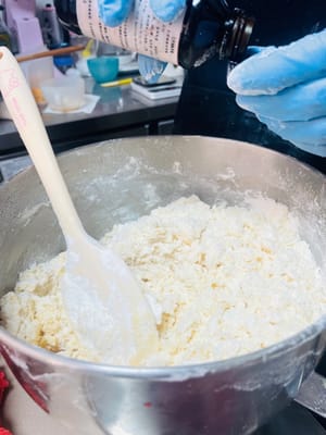 Ayak tepung kue ke dalam mentega kocok dan aduk dengan spatula hingga tidak ada gumpalan. Jangan menguleni terlalu keras, karena akan menyebabkan tepung membentuk gluten dan memengaruhi tekstur.