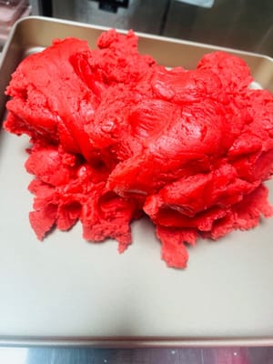 Menambahkan Pewarna:
Jika Anda ingin mewarnai kue, tambahkan pewarna (misalnya, hijau, merah) sesuai selera. Tidak ada takaran yang ditentukan; tambahkan pewarna secara bertahap, aduk terus, hingga mencapai warna yang diinginkan (resep ini menggunakan sekitar 1 tutup botol). Setelah menambahkan pewarna, aduk rata adonan dengan tangan.