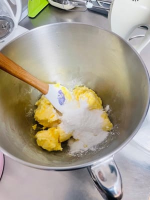 Masukkan mentega lunak ke dalam mangkuk, tambahkan gula halus dan garam, lalu kocok dengan pengocok berkecepatan sedang hingga mentega mengembang dan pucat.
