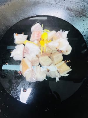 È meglio chiedere al macellaio di arrostire la cotenna del maiale, lavare e asciugare la pancetta, tagliarla a pezzi, metterla in una pentola, aggiungere acqua fredda, grani di pepe di Sichuan, 5 fette di zenzero e vino da cucina. Fate bollire l'acqua per 10 minuti, quindi toglietela dalla pentola, lavatela e mettetela da parte.