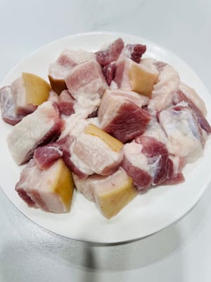È meglio chiedere al macellaio di arrostire la cotenna del maiale, lavare e asciugare la pancetta, tagliarla a pezzi, metterla in una pentola, aggiungere acqua fredda, grani di pepe di Sichuan, 5 fette di zenzero e vino da cucina. Fate bollire l'acqua per 10 minuti, quindi toglietela dalla pentola, lavatela e mettetela da parte.