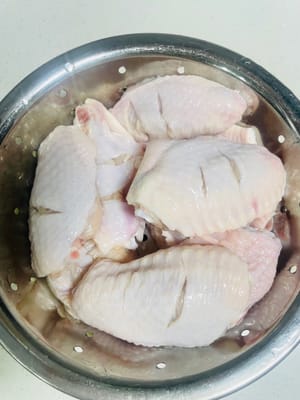 1. Preparación de las alitas de pollo: Coloque las alitas en una tabla de cortar y córtelas por la mitad con un cuchillo. Coloque las alitas en un recipiente con agua, añada la cantidad adecuada de sal y vinagre blanco, lávelas a mano varias veces, deje que la sal y el vinagre blanco eliminen por completo las impurezas y el olor a pescado de la superficie. Luego, enjuáguelas repetidamente con agua limpia, escurra el agua y reserve.
