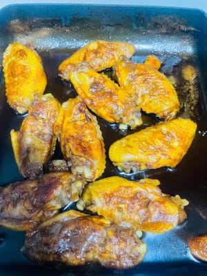 Llevar a ebullición a fuego alto, luego bajar a fuego medio-bajo, tapar la olla y cocinar a fuego lento durante unos 15 minutos. Durante este tiempo, puede abrir la tapa para revisar y usar una espátula para remover las alitas de pollo y asegurarse de que estén bien sazonadas. Cuando la salsa espese, subir a fuego alto para reducirla y que envuelva bien las alitas. Luego, apagar el fuego y servir.